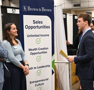 A Brown & Brown representative talks with a student at an FSU career fair.
